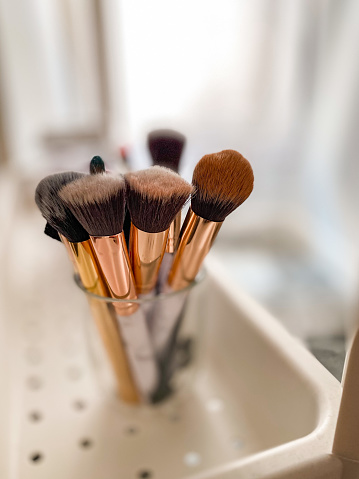 Glass cup with clean makeup brushes