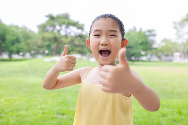 Little Girl is Thumbs Up with Both Hands stock photo