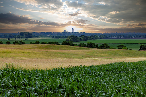 Des Moines seen in the distance across a farm field at sunrise.