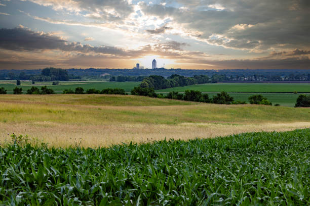 Des Moines Skyline Across Farm Des Moines seen in the distance across a farm field at sunrise. iowa stock pictures, royalty-free photos & images