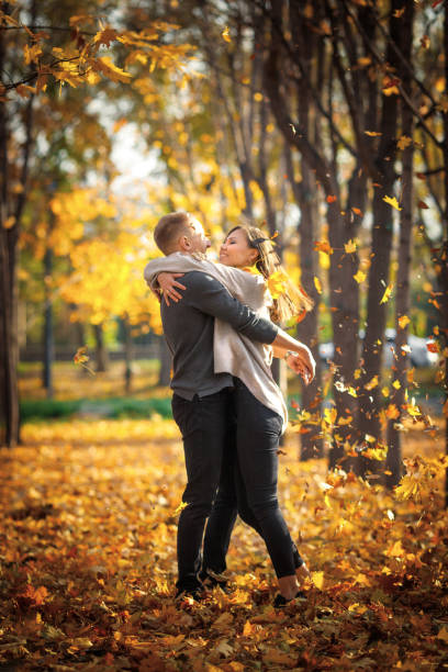 istock Romantic date in autumn park under leaf fall at sunset 1406361961