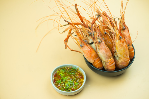 Top view of white bowl full of cooked shrimp