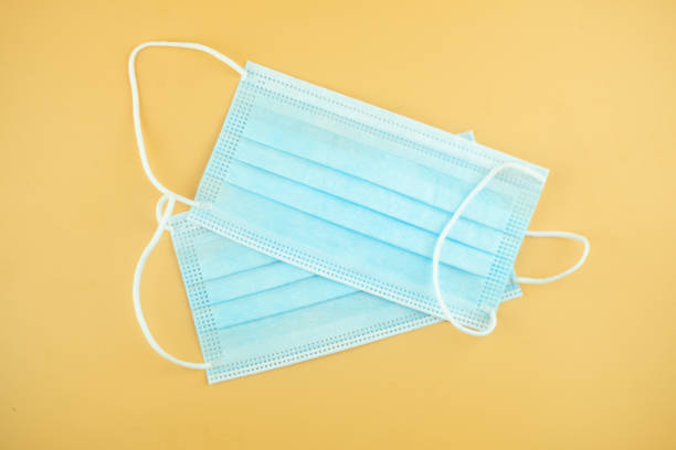 istock Blue medical face masks on a yellow background 1406363997