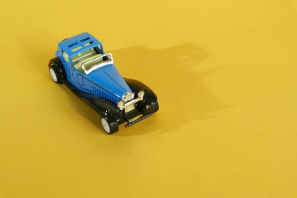 classic blue toy car isolated on yellow background. Copy space