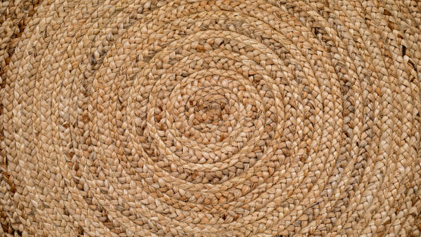 istock Round natural raffia rug with a spiral braided design and concentric circles 1406366545