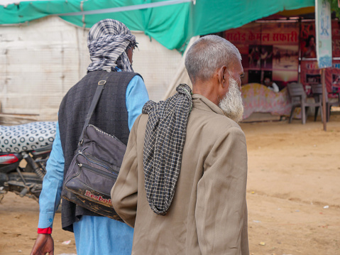 Pushkar, Rajasthan / India - November 5, 2019 : Muslim old man have fully grown beard, visiting village market in pushkar fair.