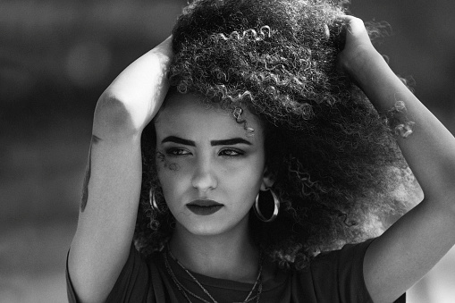 portrait of beautiful young woman with curly hair, black and white photo