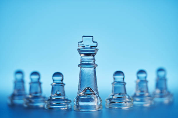 group of glass material chess pieces on chessboard