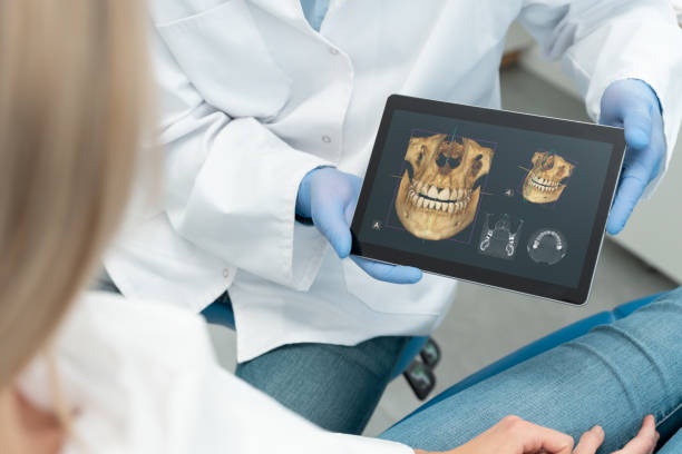 Dentist showing teeth x-ray on tablet screen stock photo