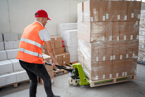 istock Male warehouse worker transferring boxes full of merchandise 1406371885