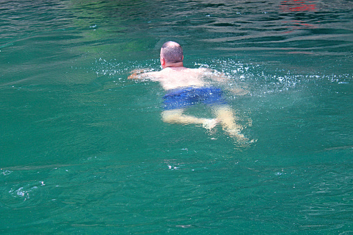 Out on the lake at Tygart Lake State Park in West Virginia, USA - Man swimming in the deep blue lake