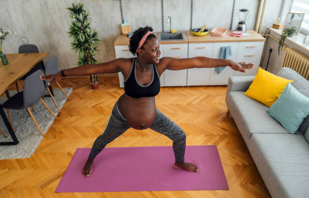 istock Pregnant woman exercising at home 1406376414