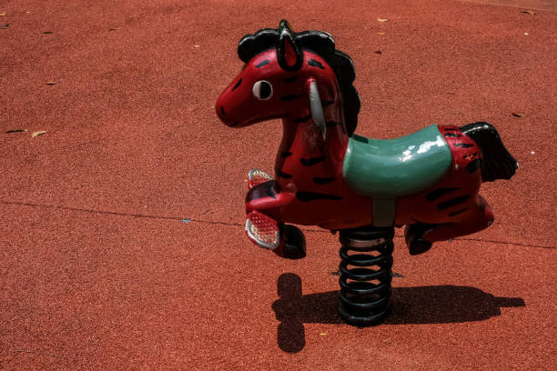 Horse shape bouncy spring rider on sunny summer day on colorful kids playground Horse shape bouncy spring rider on sunny summer day on colorful kids playground background playground spring horse stock pictures, royalty-free photos & images