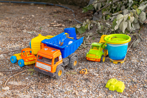 The toy cars and pickup trucks and the sand bucket that the kids play and leave in the neighborhood.