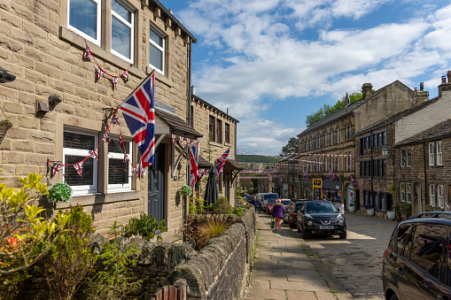 This is historic Haworth, Yorkshire, England, UK, home of the Bronte sisters.  The village is bedecked in bunting and union flags as it celebrates the Platinum Jubilee of Queen Elizabeth II.