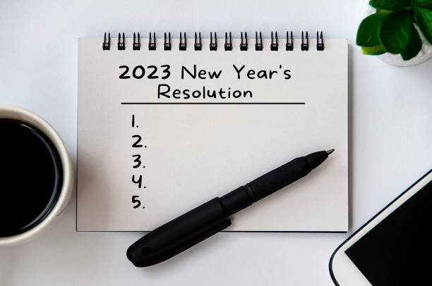 istock 2023 New Year's Resolutions text on note pad with pen, smart phone, plant and coffee. New year concept 1406382495