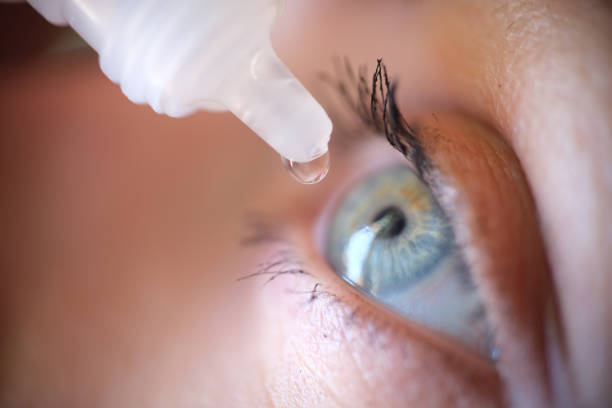 istock Drops from vial dripping into woman eye closeup 1406386094