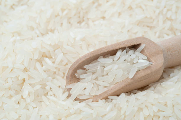 istock Raw white rice (Uncooked) in wooden scoop 1406389609