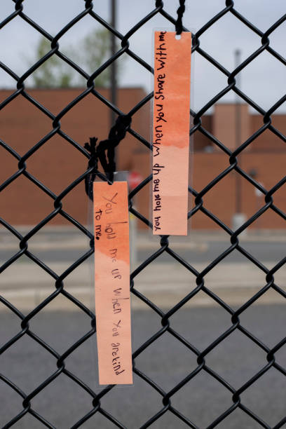 istock Kid's emotional and sentimental notes hanging from a chain link fence 1406391672