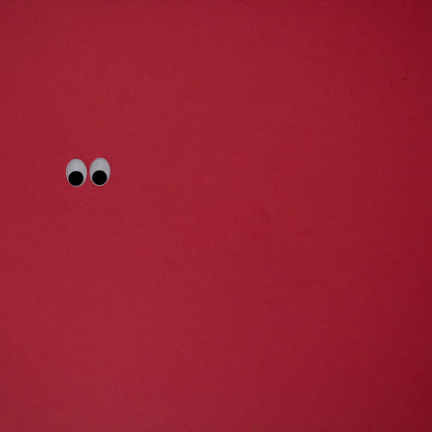 istock Eyes on red background. Flat lay concept. 1406396393