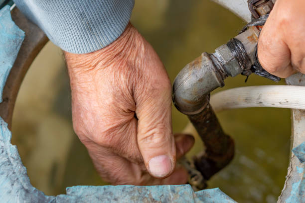istock Old hands repairing water float in water tank. 1406396436