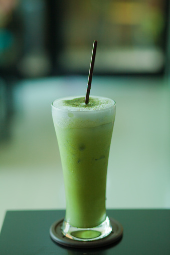 Long glass with iced thai green milk tea