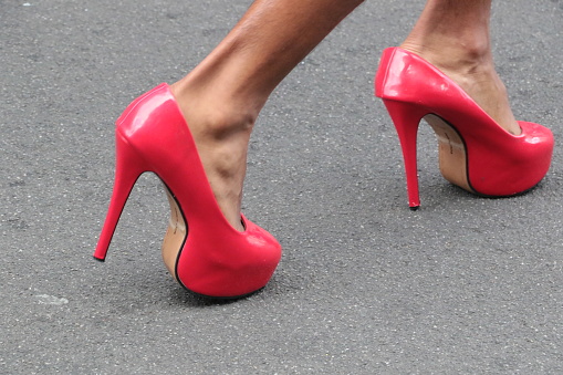 Woman standing in red shoes with high heels