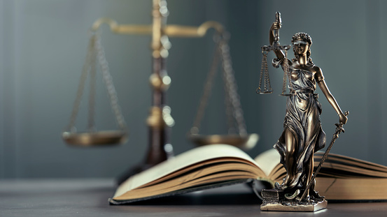Estatuto legal y legal de Lady Justice sobre la mesa con libro y escala photo