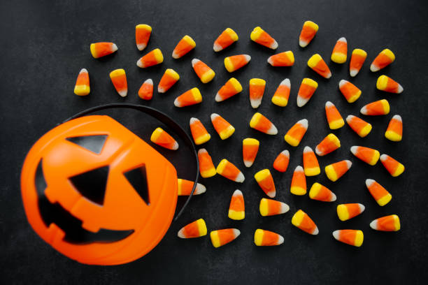 Halloween Background Candy corn candies, pumpkin basket. Traditional sweet Treats. Copy space Halloween Background Candy corn candies, pumpkin basket. Traditional sweet Treats. Copy space. candy corn stock pictures, royalty-free photos & images