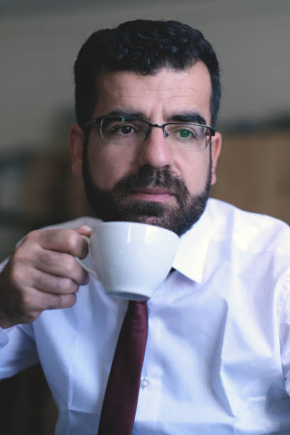 istock businessman sips coffee in office during business break 1406409812