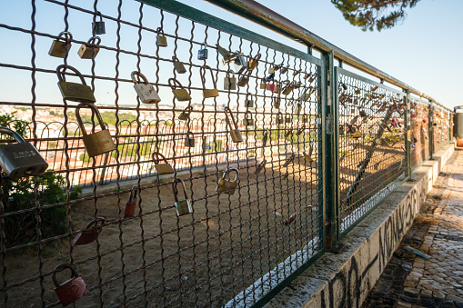 Lisboa , Portugal; 02 July 2022: Padlocks of promises of love in the network of the viewpoint of Nossa Senhora do Monte in Lisbon