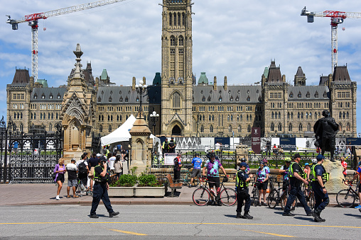 Ottawa, Canada - July 2, 2022: Parliament Hill with security entry point to screen people wishing entrance into the area during Canada Day weekend. Security and police presence was enhanced due to potential threats of another illegal occupation like the one that shut down much of the downtown area earlier in the year.