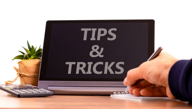 istock Tips and tricks symbol. Tablet with words 'Tips and tricks'. Businessman hand with pen, house plant. Beautiful white background. Business, tips and tricks concept, copy space. 1406411587