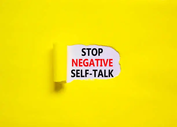 Stop negative self-talk symbol. Concept words Stop negative self-talk on a beautiful yellow background. Psychological and stop negative self-talk concept. Copy space.