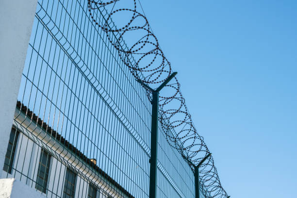 Mesh fence with barbed wire on top