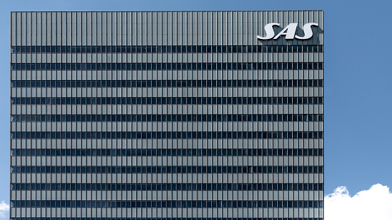 the facade of the skyscraper SAS Radisson hotel against the blue sky,  with a big SAS sign, Copenhagen, July 2, 2022