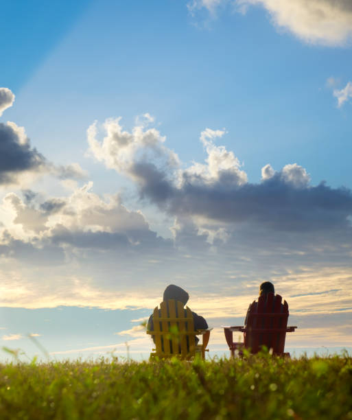 istock Two happy women sitting by seaside and watching view 1406414410