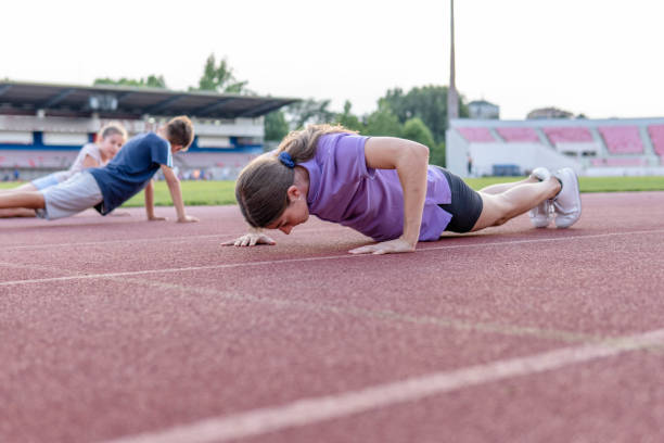 istock Young runners doing push ups on race track 1406418624
