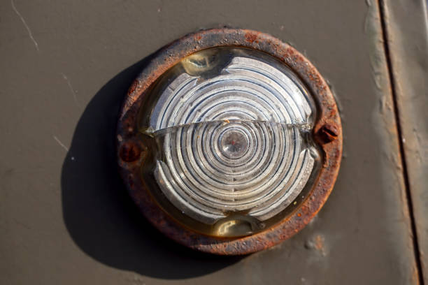 an old rusty light bulb on a car, an old light bulb and glass to protect it in rust