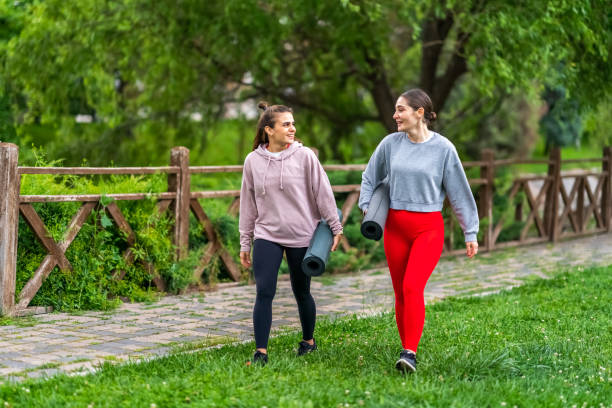 istock Two female walking outdoor with exercises mats 1406424224