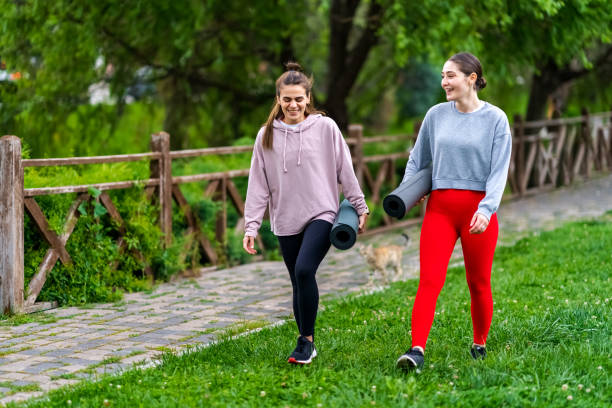 istock Two female walking outdoor with exercises mats 1406424242