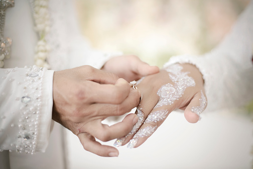 man holding his girlfriend's hand and woman showing her ring
