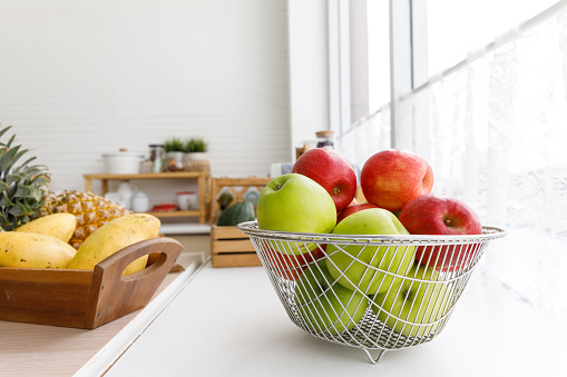 Green Apples and Red Apples in the basket put on table in the kitchen, Healthy food concept