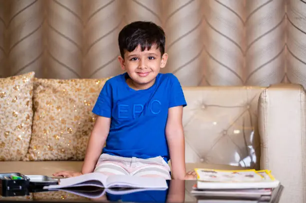 Photo of Shot of an hardworking little boy doing his schoolwork at home