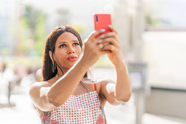 istock Transsexual woman taking a selfie outdoors. Close up 1406455821