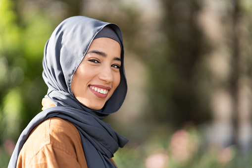 Portrait with copy space of a smiling muslim woman outdoors