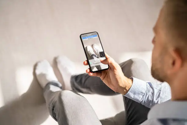 Photo of Man Trying Virtual Sneakers In Online Shop