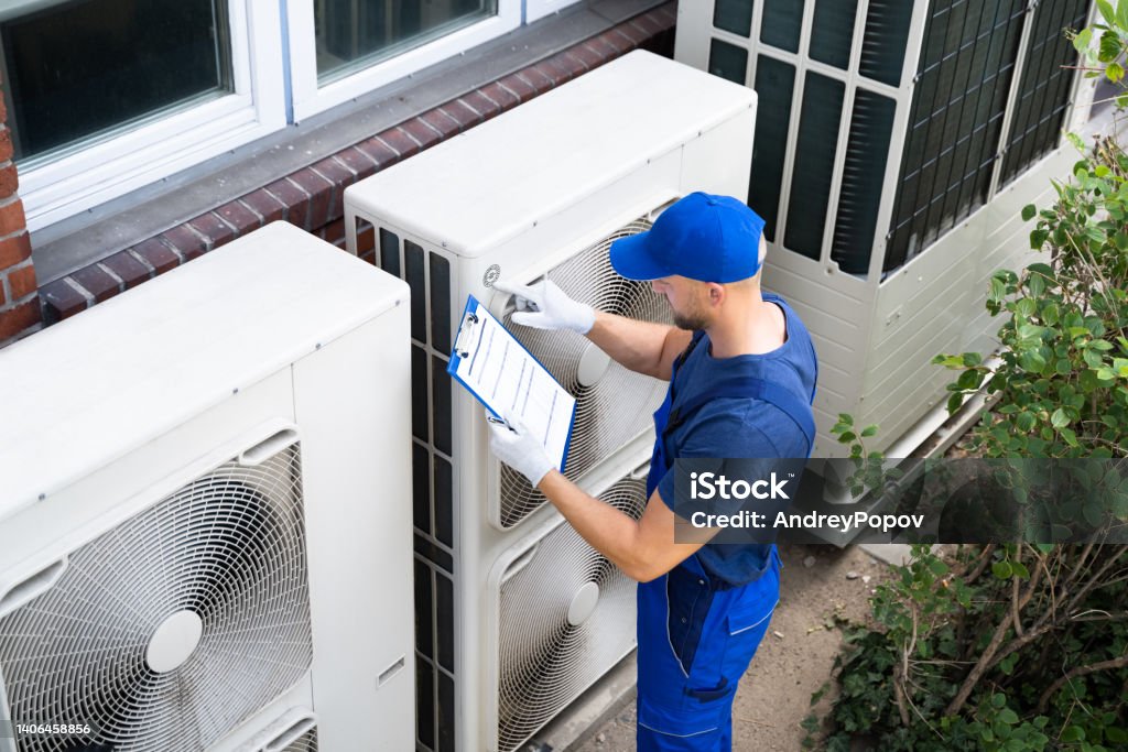 An Electrician Men Checking Air Conditioning Unit Two Electricians Men Wearing Safety Jackets Checking Air Conditioning Unit On Building Rooftop Air Conditioner Stock Photo