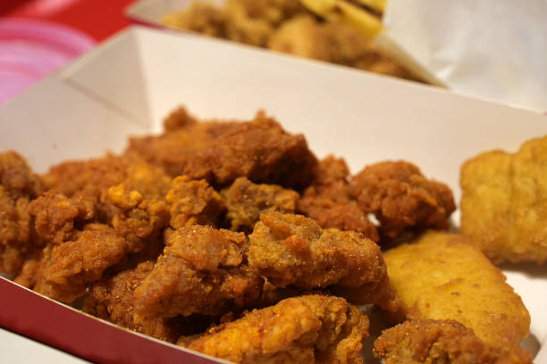 istock Fried breaded chicken fillet in white cardboard box isolated on burred background 1406465679