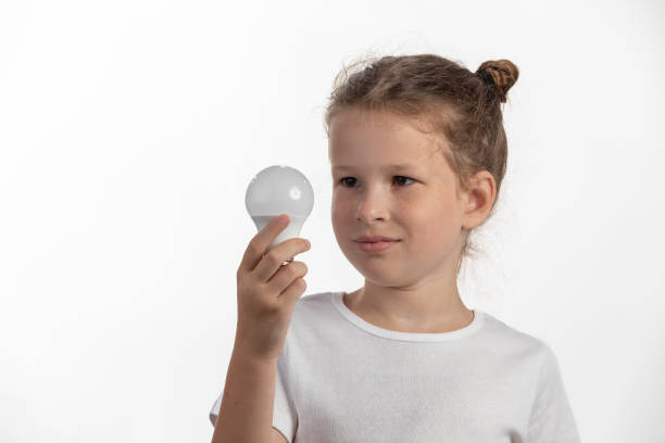Electricity and education - Young child holding a LED lightbulb